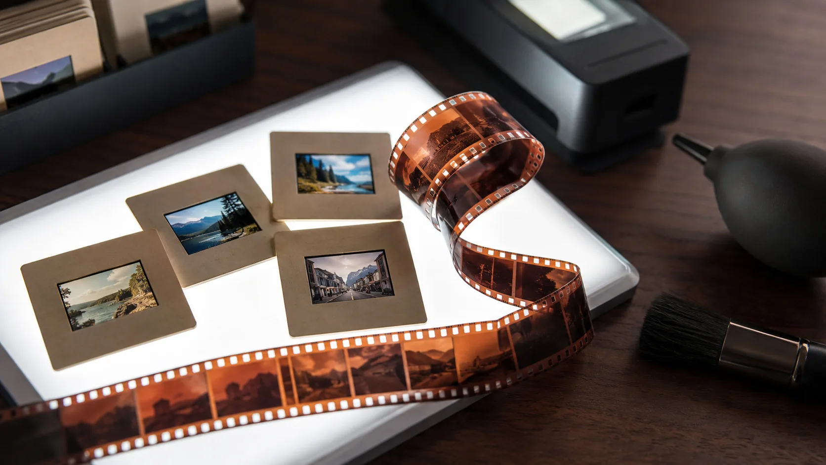 Dias und ein Negativstreifen auf einem Leuchttisch neben einem Filmscanner