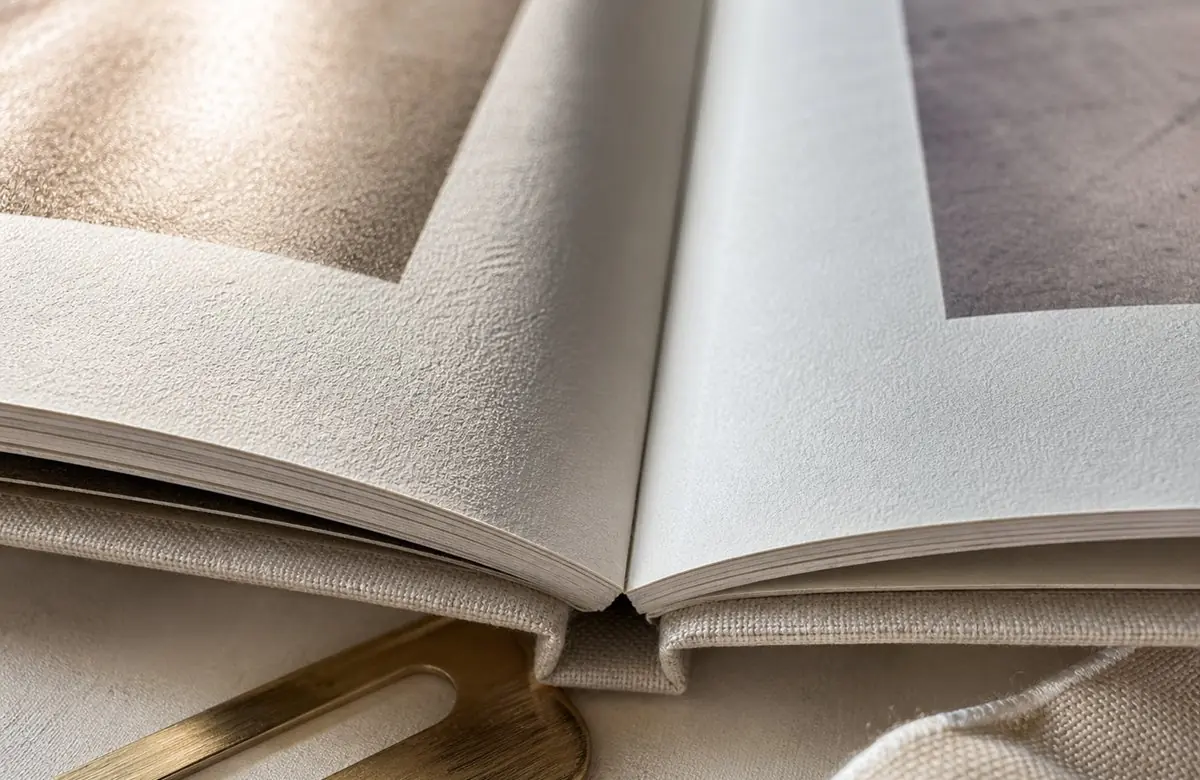 Nahaufnahme aufgeschlagener Fotobuchseiten, Detail von Papierqualität und hochwertiger Bindung
