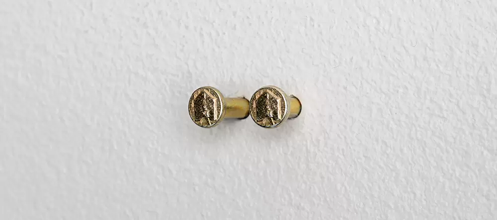 Zwei Nägel aus dem Aufhängeset in Waage in der Wand