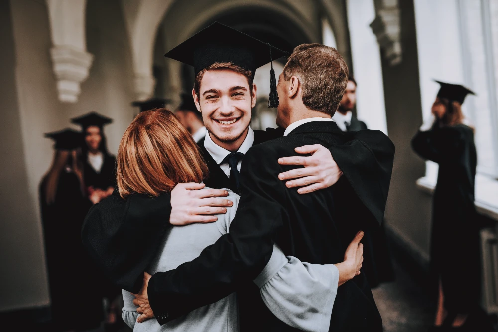 Junge Absolventen feiern fröhlich ihren Abschluss mit Abitur Sprüchen und Glückwünschen