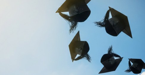 Junge Absolventen feiern fröhlich ihren Abschluss mit Abitur Sprüchen und Glückwünschen