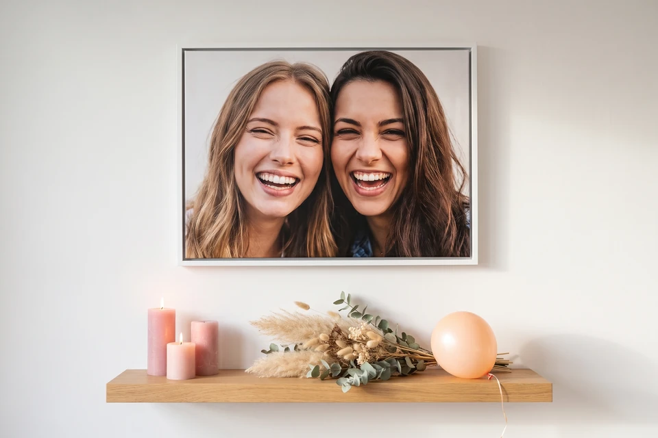 Foto zweier Freundinnen im weißen Schattenfugenrahmen über einem Wandbord mit Kerzen