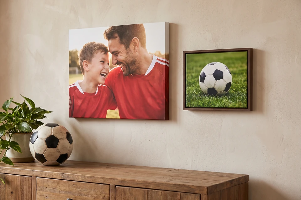 Leinwand mit Vater und Sohn im Fußballtrikot und Fußballfoto im Schattenfugenrahmen über einem Sideboard