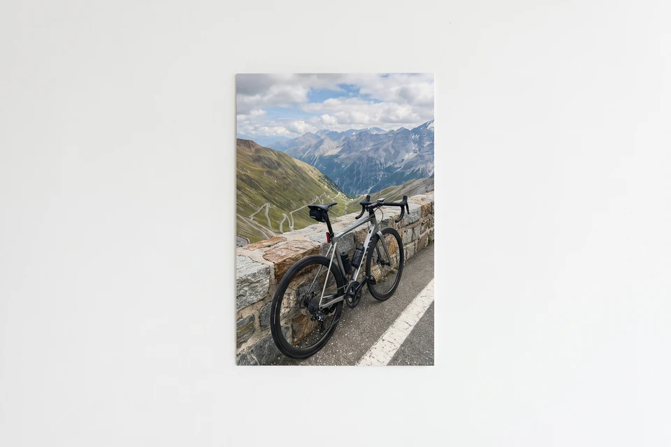 Fotoposter mit Rennrad in den Bergen an einer weißen Wand