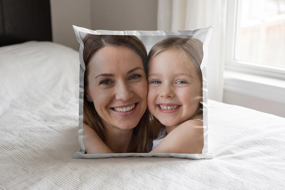 Fotokissen mit Foto von Mutter und Tochter auf einem Bett
