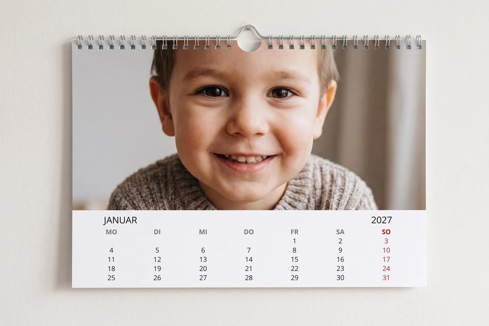 Wandkalender mit Enkelfoto an einer hellen Wand