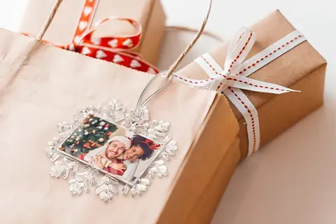 Anhänger in Schneeflockenform mit Foto auf einem Geschenk