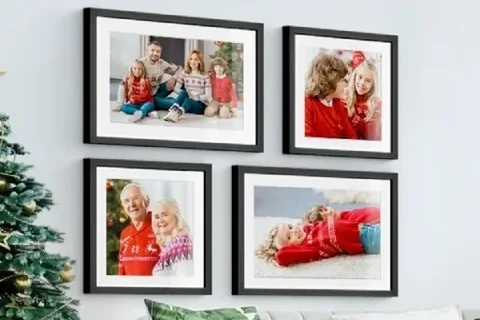 Gerahmte Familienfotos an der Wand neben dem Weihnachtsbaum