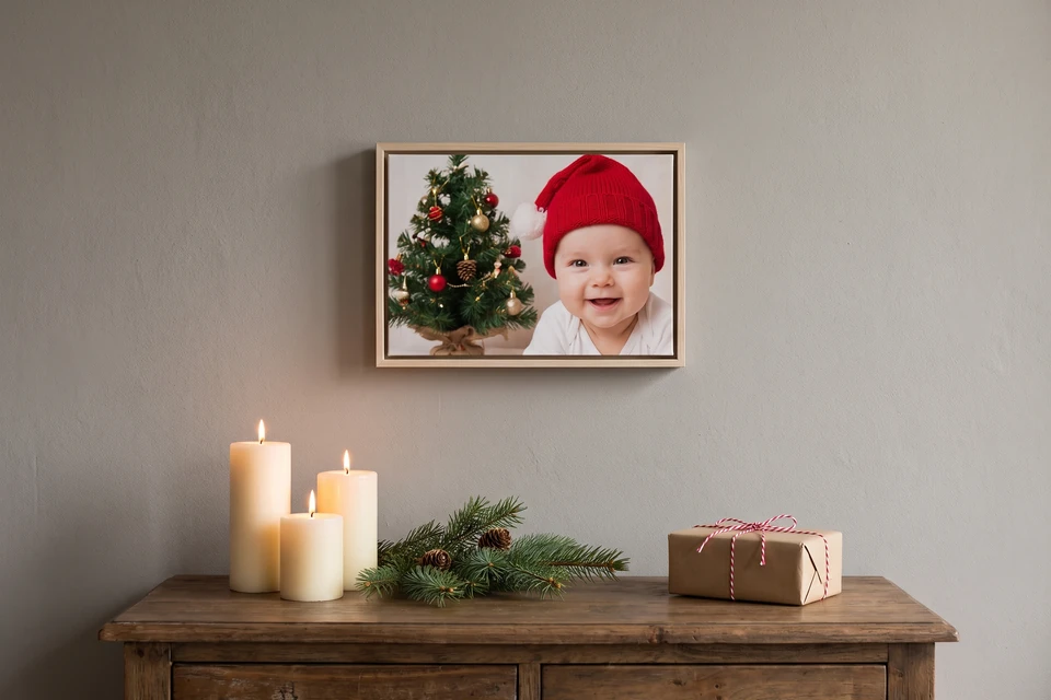 Babyfoto mit Weihnachtsmütze im Schattenfugenrahmen Naturholz über einer Kommode