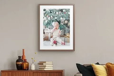 Gerahmtes Babyfoto an der Wand über einer Kommode