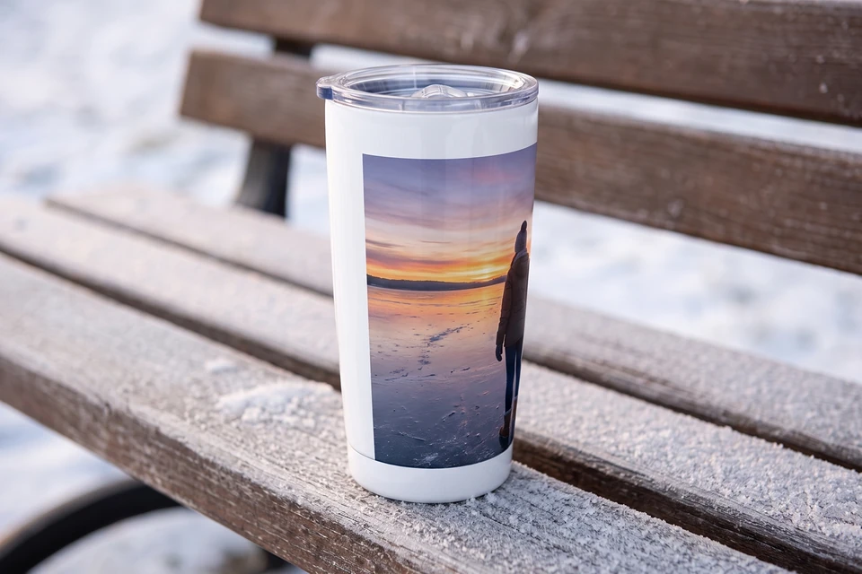 Thermobecher mit Winterfoto auf einer Bank