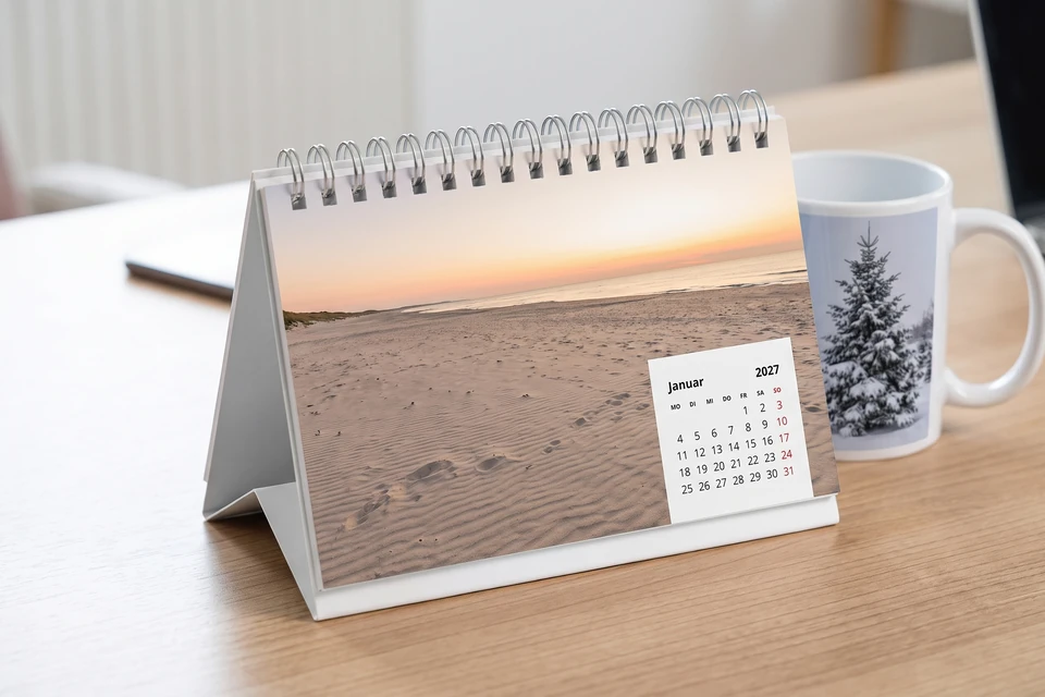 Tischkalender und Fototasse auf einem Schreibtisch