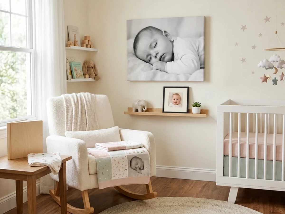 Babyfoto in Schwarz-Weiß als Leinwand über dem Schaukelstuhl im Kinderzimmer