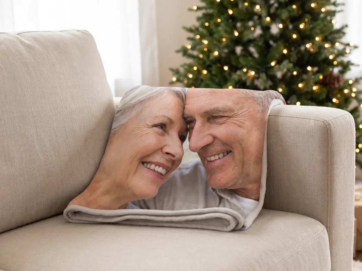 Fotodecke mit Paarfoto auf einem Sofa vor dem Weihnachtsbaum