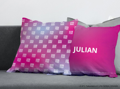 GZSZ Kissen pink Logo auf einer Couch